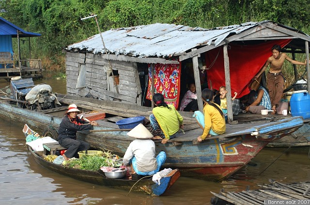 PICT5822.JPG - Cambodge, village flottantLes bras des rivières sont les rues des villages flottants qui se déplacent au gré des crues du lac Tonlé Sap (Cambodge). Elles sont sillonnées par de nombreux commerçants chargés de marchandises de toutes sortes. On y voit la pauvreté, mais pas la misère.